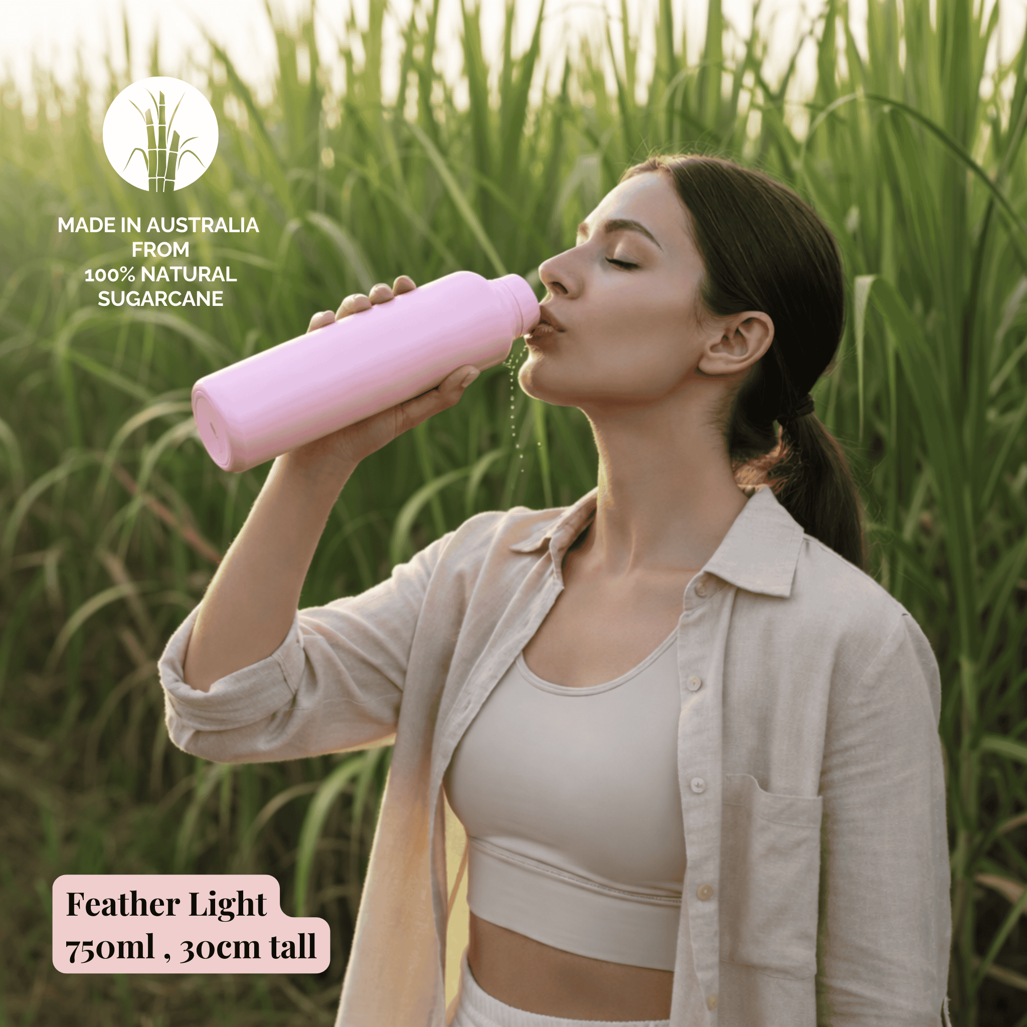 Woman drinking from a pink bottle in a sugarcane field